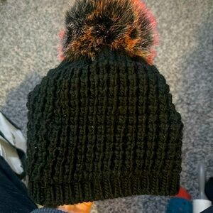 NWOT. Woman’s Kyi Kyi Canada black Acrylic and Wool blend winter hat. red poof.